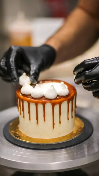 stock image chef decorating the top of a frosted buttercream cake