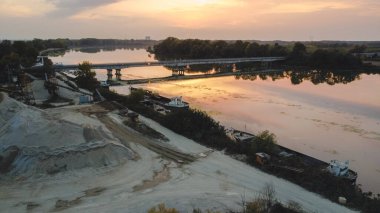 Sonbaharda nehirde bir köprünün üzerinde gün batımı