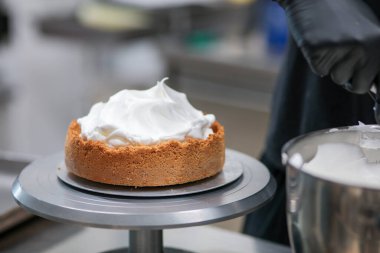 Yemek şefi profesyonel mutfakta limonlu turta hazırlıyor.