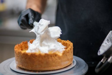 Yemek şefi profesyonel mutfakta limonlu turta hazırlıyor.