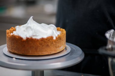 Yemek şefi profesyonel mutfakta limonlu turta hazırlıyor.
