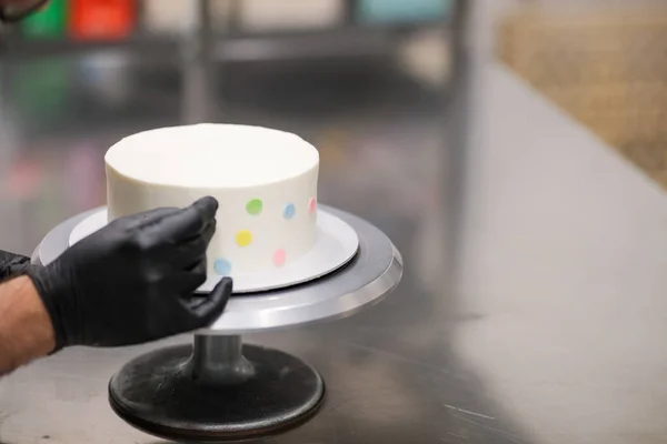 stock image decorating a frosted cup cakes with multi colored dots