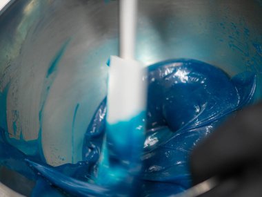 Pasta şefi pasta tasarımcısı mutfak laboratuarında mavi beyaz peynirli kek hazırlıyor.