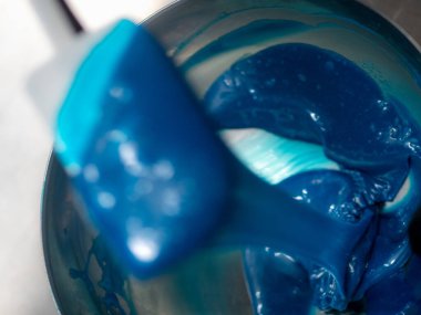 Pasta şefi pasta tasarımcısı mutfak laboratuarında mavi beyaz peynirli kek hazırlıyor.