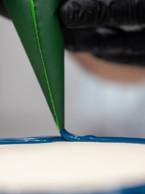 Pasta şefi pasta tasarımcısı mutfak laboratuarında mavi beyaz peynirli kek hazırlıyor.