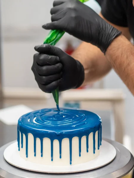 pastry chef cake designer preparing blue white cheesecake in kitchen lab