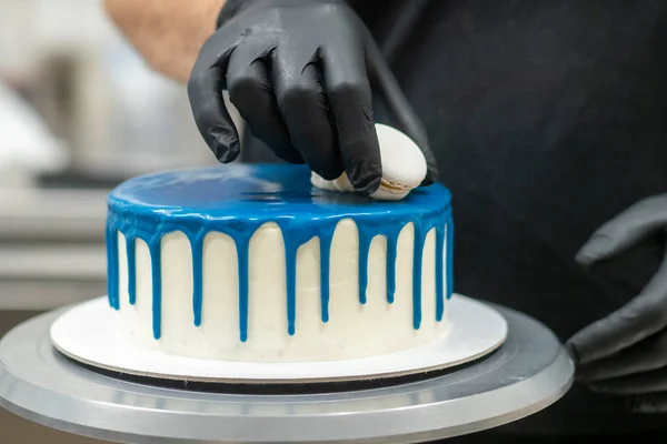 pastry chef cake designer preparing blue white cheesecake in kitchen lab