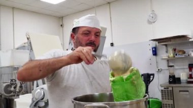 Bir grup keki süslemek için dondurulmuş dolgu poşeti kullanan bir zanaatkar.