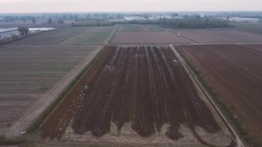 İnsansız hava aracı, çiftçinin çamurlu bir lağım tarlasını sürdüğü video görüntülerini çekiyor