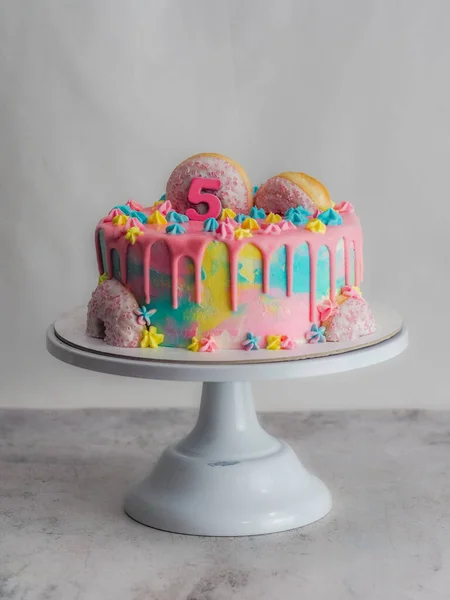 用甜甜圈和毛绒刷过的皇家星光洒落在白色的工作室镜头上的粉红糖霜蛋糕的特写 — 图库照片