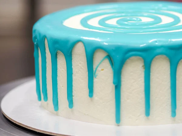 糕点厨师蛋糕设计师在厨房用管道袋装饰绿松石蓝色白霜芝士蛋糕 — 图库照片