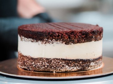 Şef pasta tasarımcısı kremalı pasta tabanı hazırlıyor. Dondurulmuş süsleme ve süsleme için.