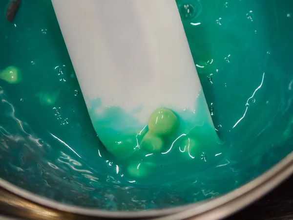 stock image melting piping bag light blue turquoise green filling to drip a frosted cake