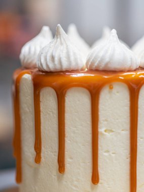 Profesyonel fırıncı çikolatalı ve kremalı pastayı tuzlu karamel ile süslüyor.