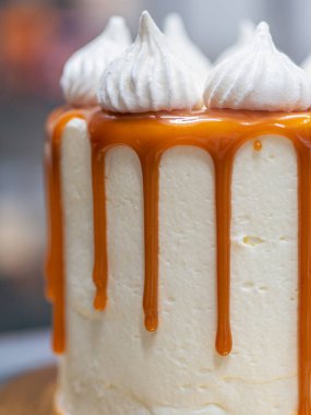 Profesyonel fırıncı çikolatalı ve kremalı pastayı tuzlu karamel ile süslüyor.