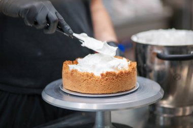 Yemek şefi profesyonel mutfakta limonlu turta hazırlıyor.