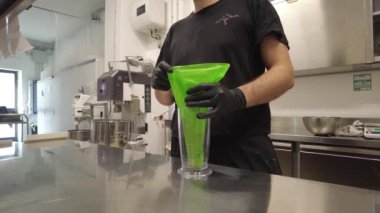 Şef leylak kremalı pasta için ganache dolduruyor.