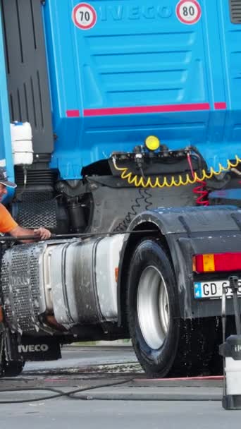 在洗车时使用自助设备喷涂蓝色半卡车外部的男子 — 图库视频影像