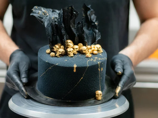 Pasta şefi korku dolu siyah muertoları bitiriyor. Doğum günü pastası, altın yenebilir kafatasları ve siyah pirinç kağıdı yelkenleriyle süsleniyor.