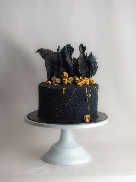 糕点厨师用金色可食用的骷髅和黑米纸帆来装饰恐怖的黑色玉米片生日蛋糕 — 图库照片
