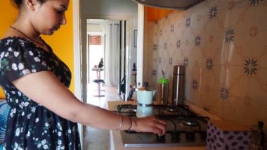 Genç Hintli güzel bir kadının evde moka italyan tarzı kahve hazırlayıp servis ettiği görüntüler.