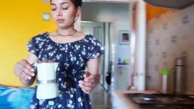 Genç Hintli güzel bir kadının evde moka italyan tarzı kahve hazırlayıp servis ettiği görüntüler.