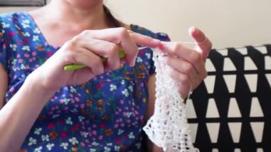 40 'lı yaşlarda Latin kökenli genç bir kadın evde oturmuş kedi besliyor ve evcil hayvan şirketinin 4K görüntülerini seyrediyor.