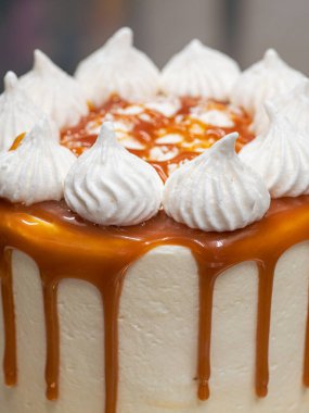 Profesyonel fırıncı çikolatalı ve kremalı pastayı tuzlu karamel ile süslüyor.