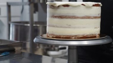 Şef iş yerinde damlatan bir pasta hazırlıyor.