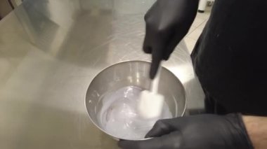 Şef leylak kremalı pasta için ganache dolduruyor.
