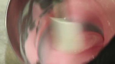 Pasta şefi pipo poşetini karıştırıyor. Renk derecelendirme için yenilebilir pembe boyayla karıştırılmış. Ve pasta tepesi görüntüsü.