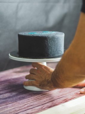 Siyah mat yenilebilir boyayla dondurulmuş süngerimsi doğum günü pastası ve stüdyoda izole edilmiş kötü kedi baskısı.