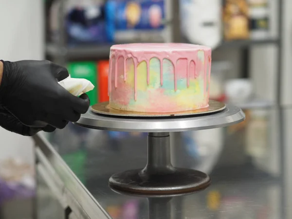 stock image pasty chef artisan squeeze piping bag filling mixed with edible pink paint for dripping color grading frosted rainbow pastel cake