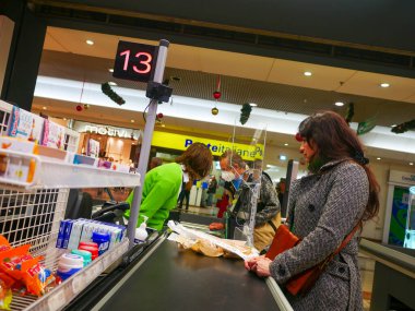 Cremona, İtalya - Aralık 2022 Latin kadın süpermarkette market alışverişi için kasiyer