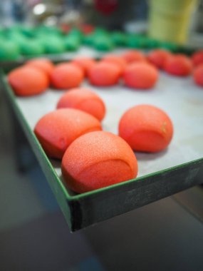 Fırıncı şefi kırmızı menekşe sarısı ve yeşil küçük küçük 30 gramlık renkli çörekler yapıyor.