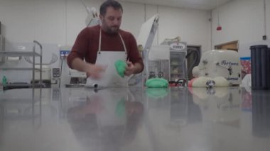 Piacenza, Italy - December 2022 creative baker kneading massaging smoothing cutting coloured dough for bread , pizza focaccia and buns for catering party finger food and appetizer