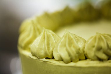 Pasta şefi kremalı helezon fıstıklı girdaplar yapıyor katmanlı yeşil çikolatalı pasta