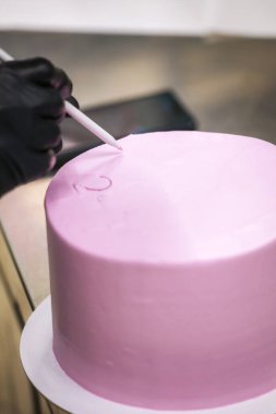 Pasta tasarımcısının üstünde mor kremalı pasta eli beyaz kremayla duygusal pişmanlık mesajı yazıyor.