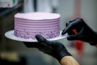 Pasta şefi fantezi serpiştiriyor pürüzsüz leylak pembesi kremalı pasta - doğum günü pastası hazırlığı