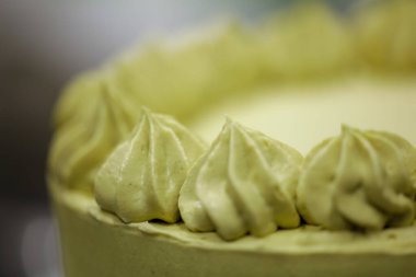 Pasta şefi kremalı helezon fıstıklı girdaplar yapıyor katmanlı yeşil çikolatalı pasta