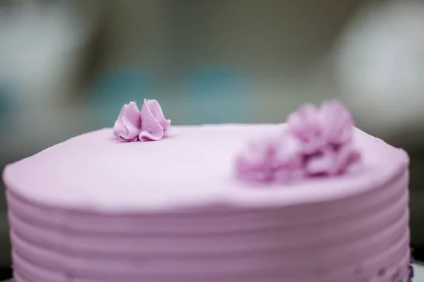 cake chef designer using pink cream filling on layered frosted chocolate lilac cake at kitchen lab