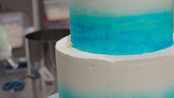 ペストリーシェフケーキデザイナーの装飾ターコイズブルーの白い霜降りチーズケーキキッチンで配管バッグ4Kビデオ — ストック動画