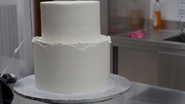 Cake Designer Spinning Smoothing Levelling Frosted Two Floorwhite Wedding Cake — Stock Video