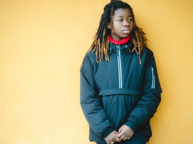 Cheerful young teengaer africna american woman dressed in sportswear relaxed with serious expression on face