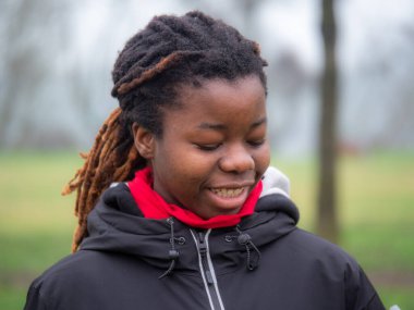 Cheerful young teengaer african american woman dressed in sportswear smiling pleasant having fun enjoying relaxing