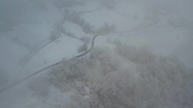 Aerial shot of winter landscape near italian apennines woods and hills covered in snow near Vezzolacca Italy drone video