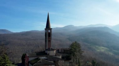 Morfasso, Piacenza, Emilia Romagna, Italy Drone view of Our Lady of Lourdes Grotto - Sperongia Parish and hills a sunny day aerial footage
