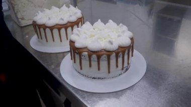 Şef hamur işi fırıncı tuzlu karamel hazırlıyor kremalı beyaz pastalar ve en üstteki 4K görüntüler.