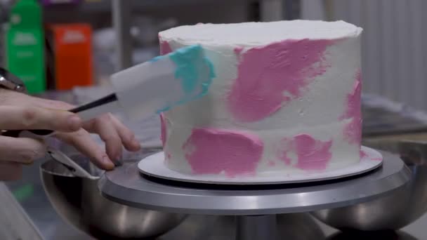 シェフペストリーデザイナーピンクイエローテールパイピングクリーム4K映像で飾られた焼き円筒形の層状ケーキを告白 — ストック動画