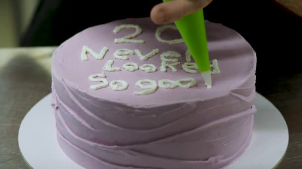20岁的糖霜蛋糕 由面包师设计 上面装饰着一只写着字母的奶油色手笔 — 图库视频影像